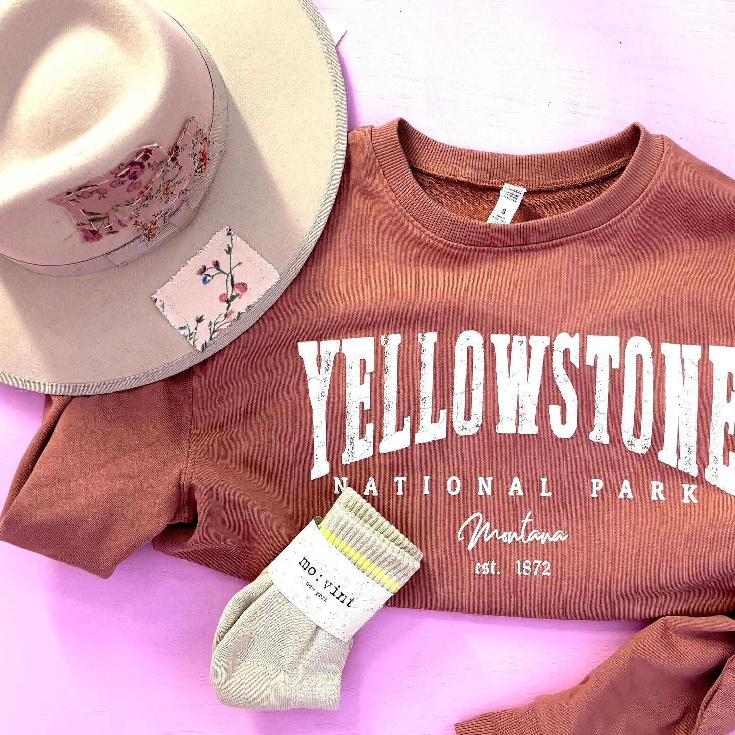 Flatlay of wide brimmed hat, socks, and Yellowstone tee