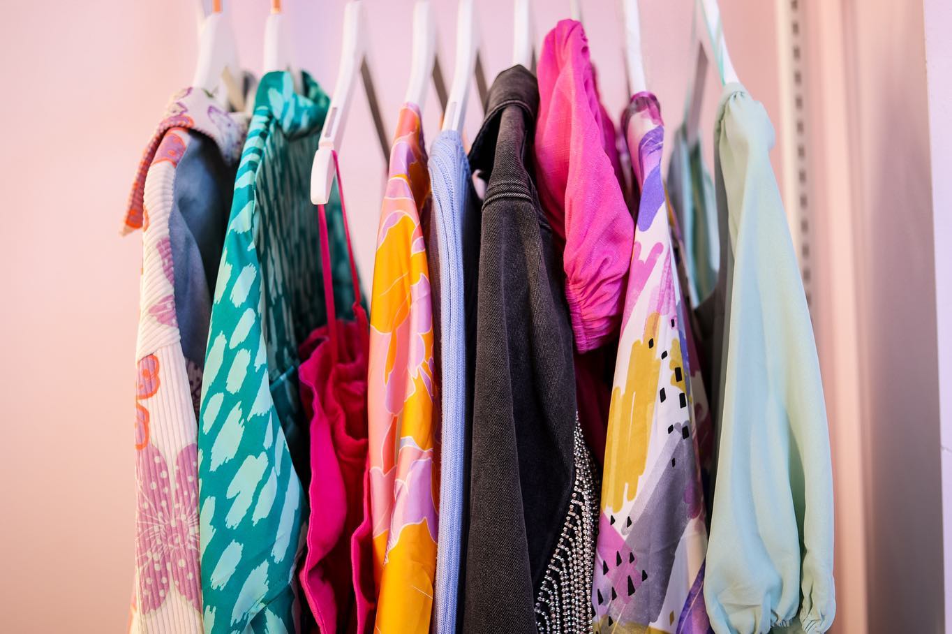 Close up of colorful clothes hanging on clothing rack